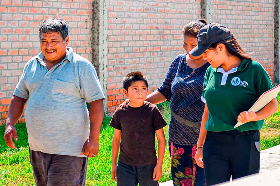 Una familia con su hijo caminando al lado de una trabajadora.