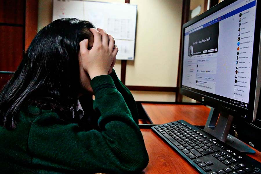Estudiante frustrada y estresada frente a la pantalla de una computadora.