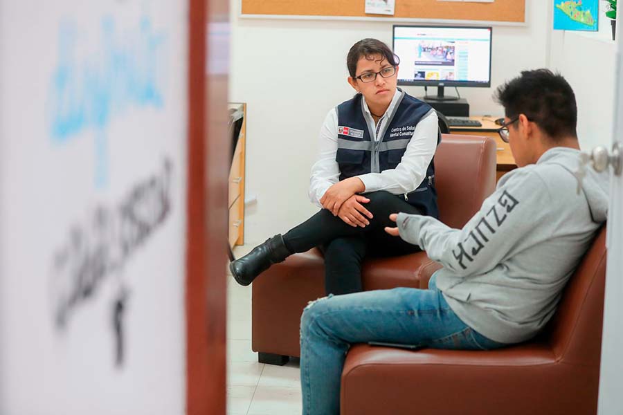 Psicóloga atendiendo a un paciente en su consultorio.