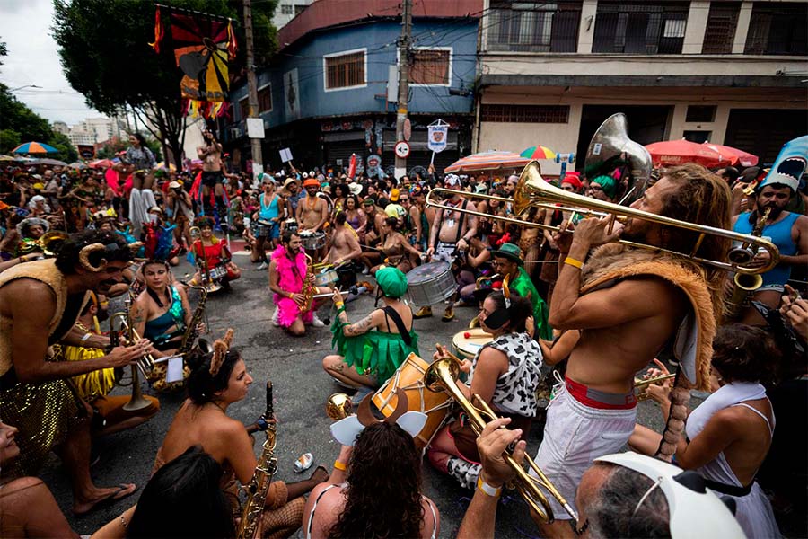 Una multitud de jóvenes celebrando con baile e instrumentos en las calles por el Carnaval de Brasil.