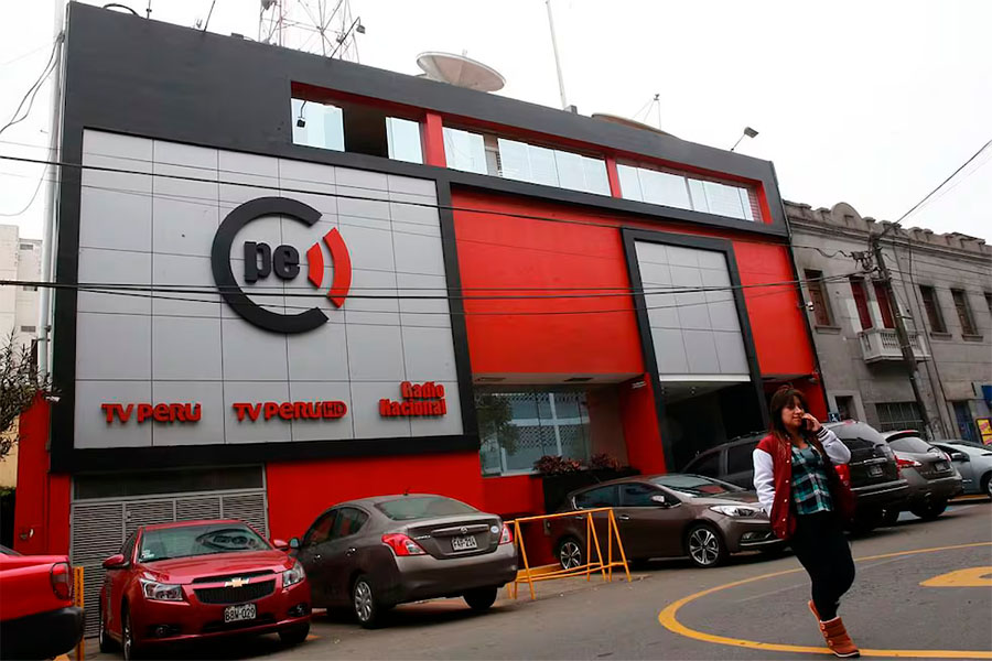Una persona caminando por afuera de las instalaciones de TV Perú y Radio Nacional.