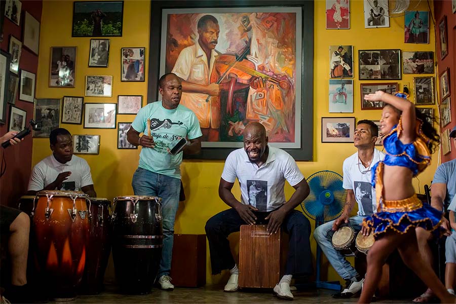 La familia Ballumbrosio tocando cajón y otras percusiones de la música afroperuana en la sala de su casa.